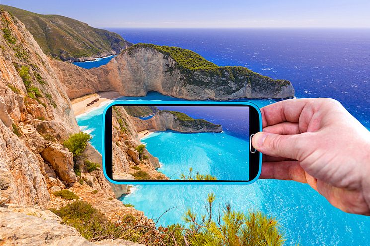 Making photos by smartphone of Navagio beach in Greece.